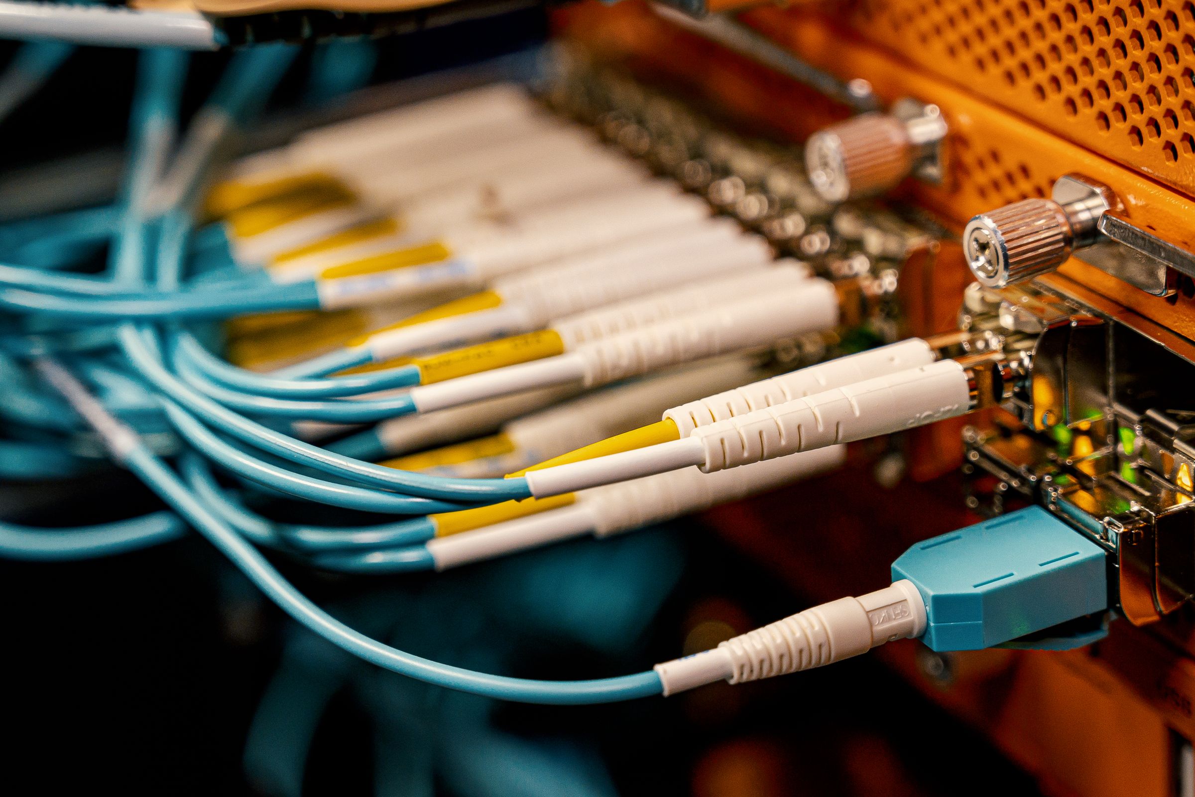 Fiber optic patch cables plugged into a network switch, illustrating an MCP data connection