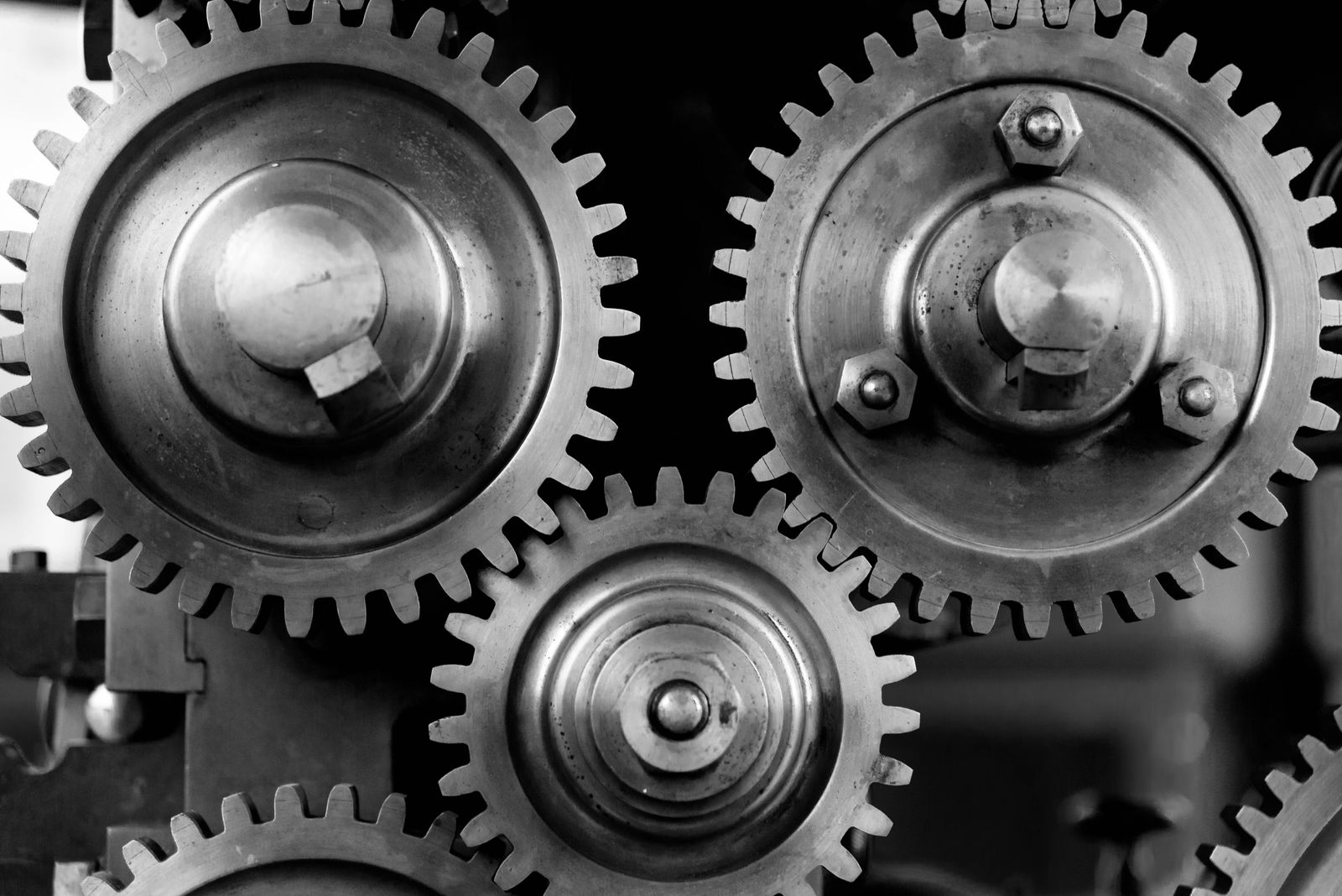 Interlocking metal gears meshing together, representing deliberate team coordination friction