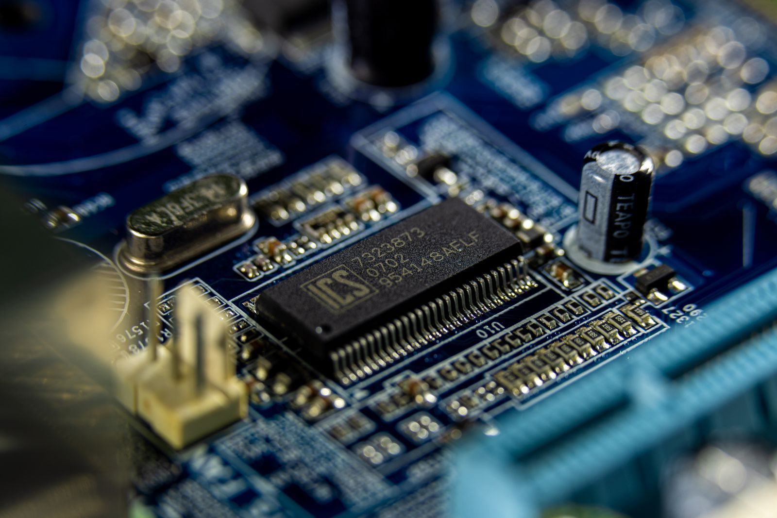 Macro close-up of a blue circuit board with memory chips and components